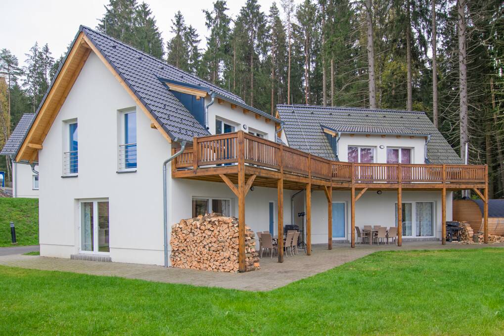 Modern holiday home Filip with spacious terrace and grill with a view of the forested hills around Lipno