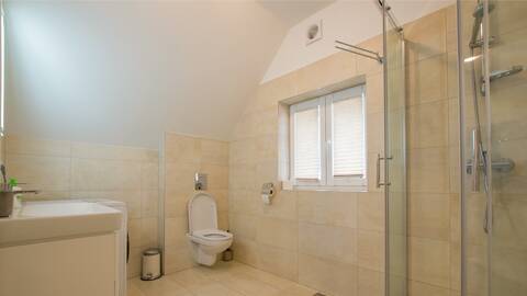 Modern bathroom in the Filip holiday home with a bathtub and light tiles